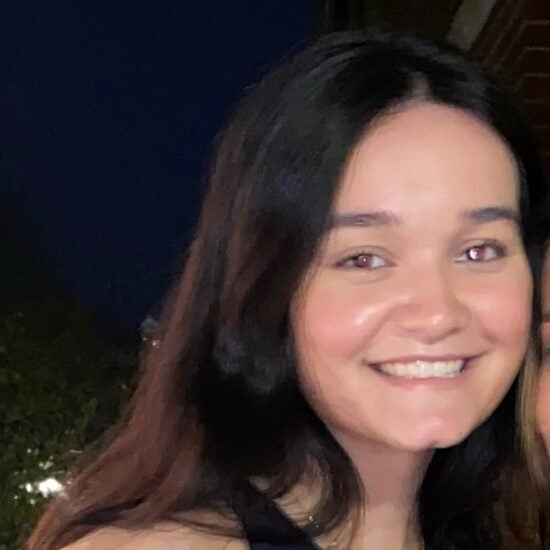 White woman with brown hair and black tank top