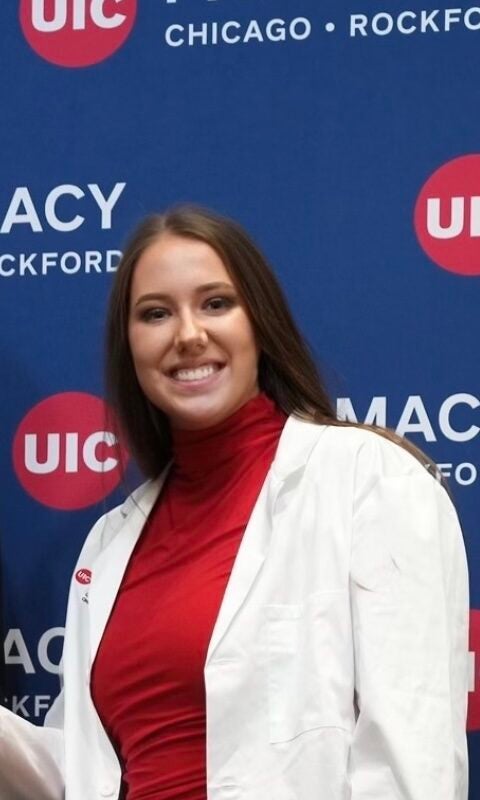 brunette woman in a whitecoat smiling